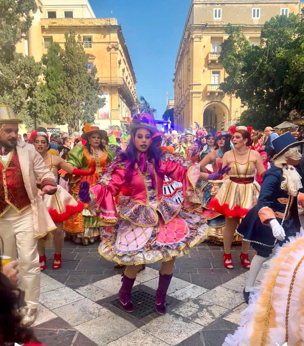 Colorful carnival parade with dancers in elaborate costumes performing during a traditional street festival in Valletta, Malta
